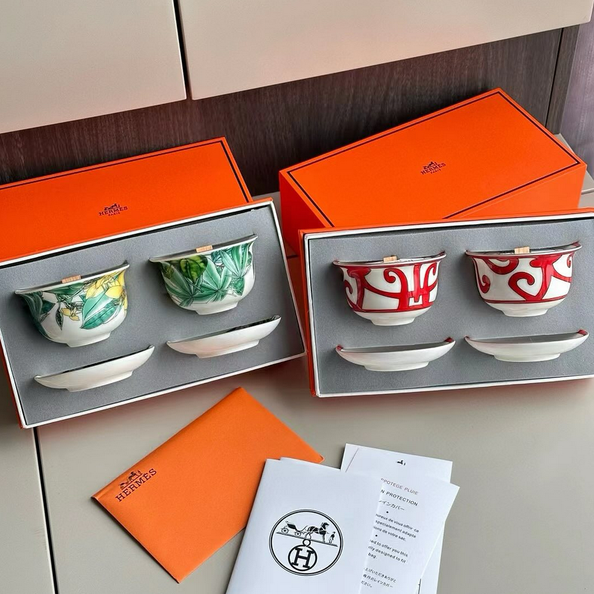 Hermès scented candles sets, including ceramic cups and small base plates.